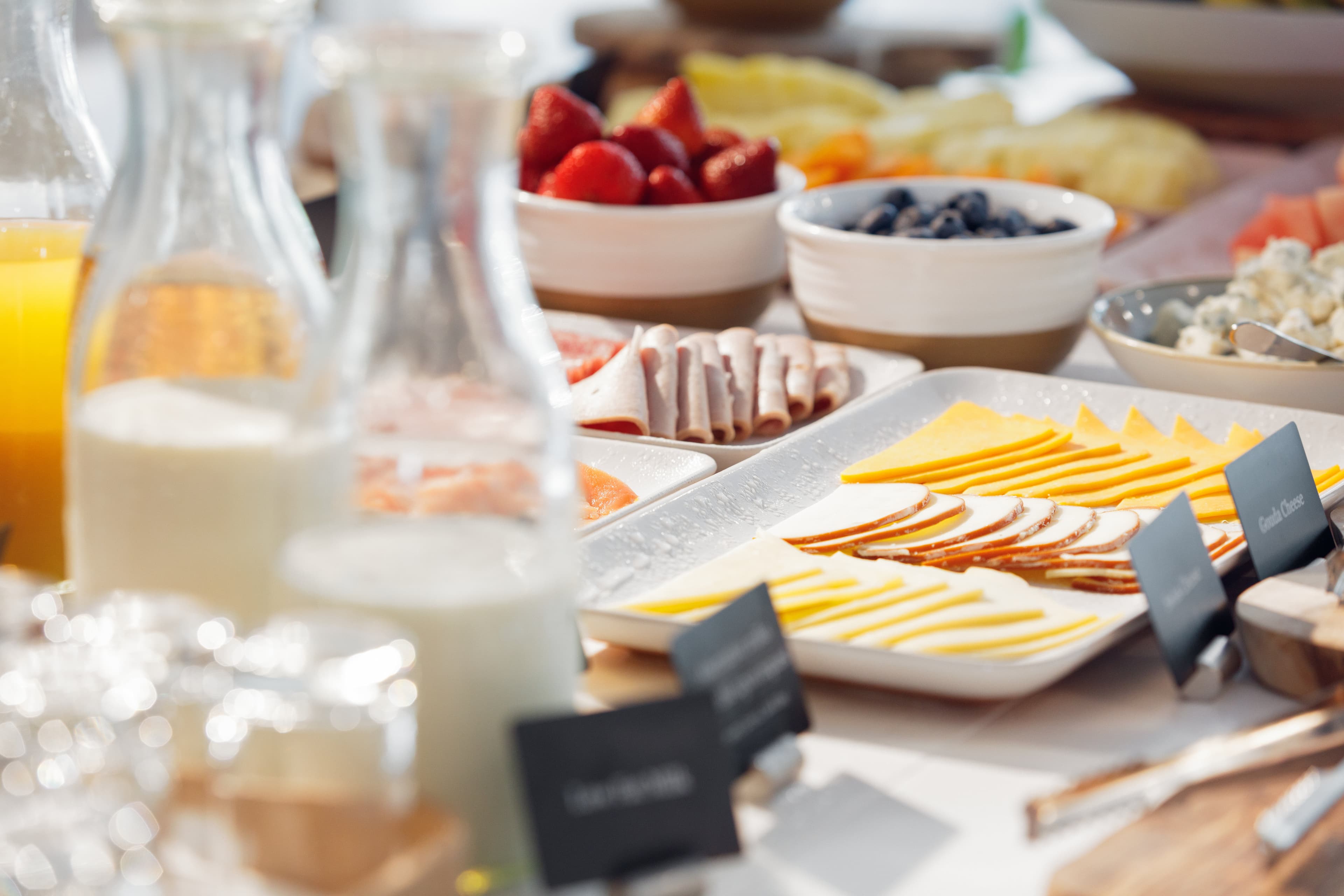 Breakfast buffet with fresh fruit, cheeses, and cold cuts
